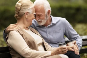 Nell'immagine due anziani su una panchina che bevono il caffè