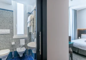 Nell'immagine si vede il bagno e la camera standard con letto matrimoniale.