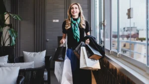 Nell'immagine una donna con delle borse di alcuni negozi tra le mani