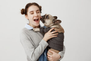 Nell'immagine una ragazza con in braccio un cane